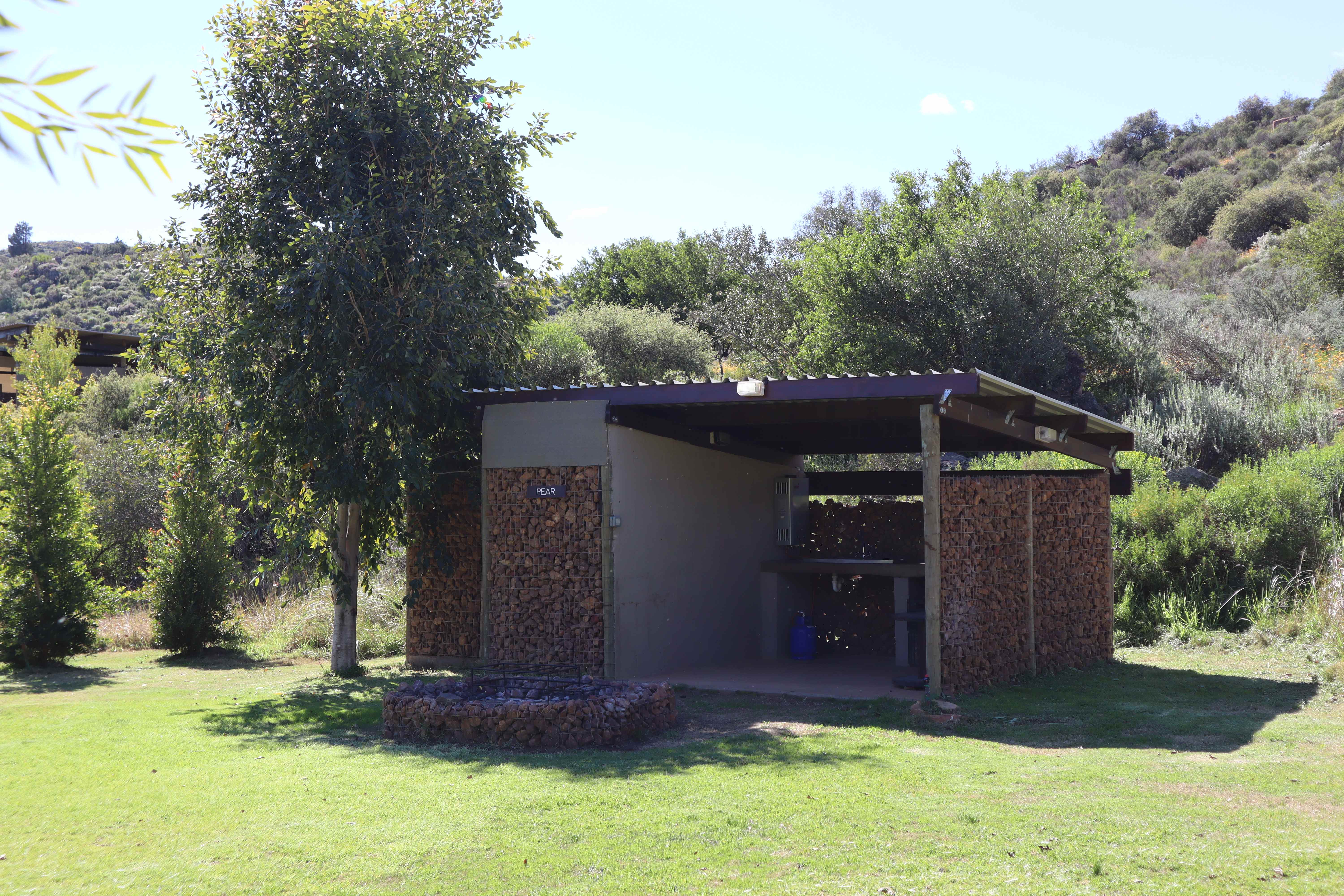 Pear campsite ablution facility with firewood storage and natural bush setting
