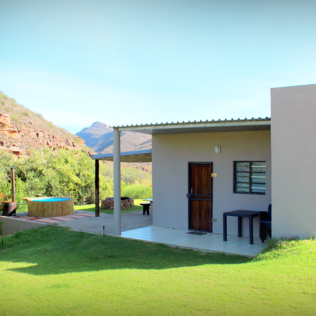 Kriedouw Farm Cottage exterior with hot tub and mountain views